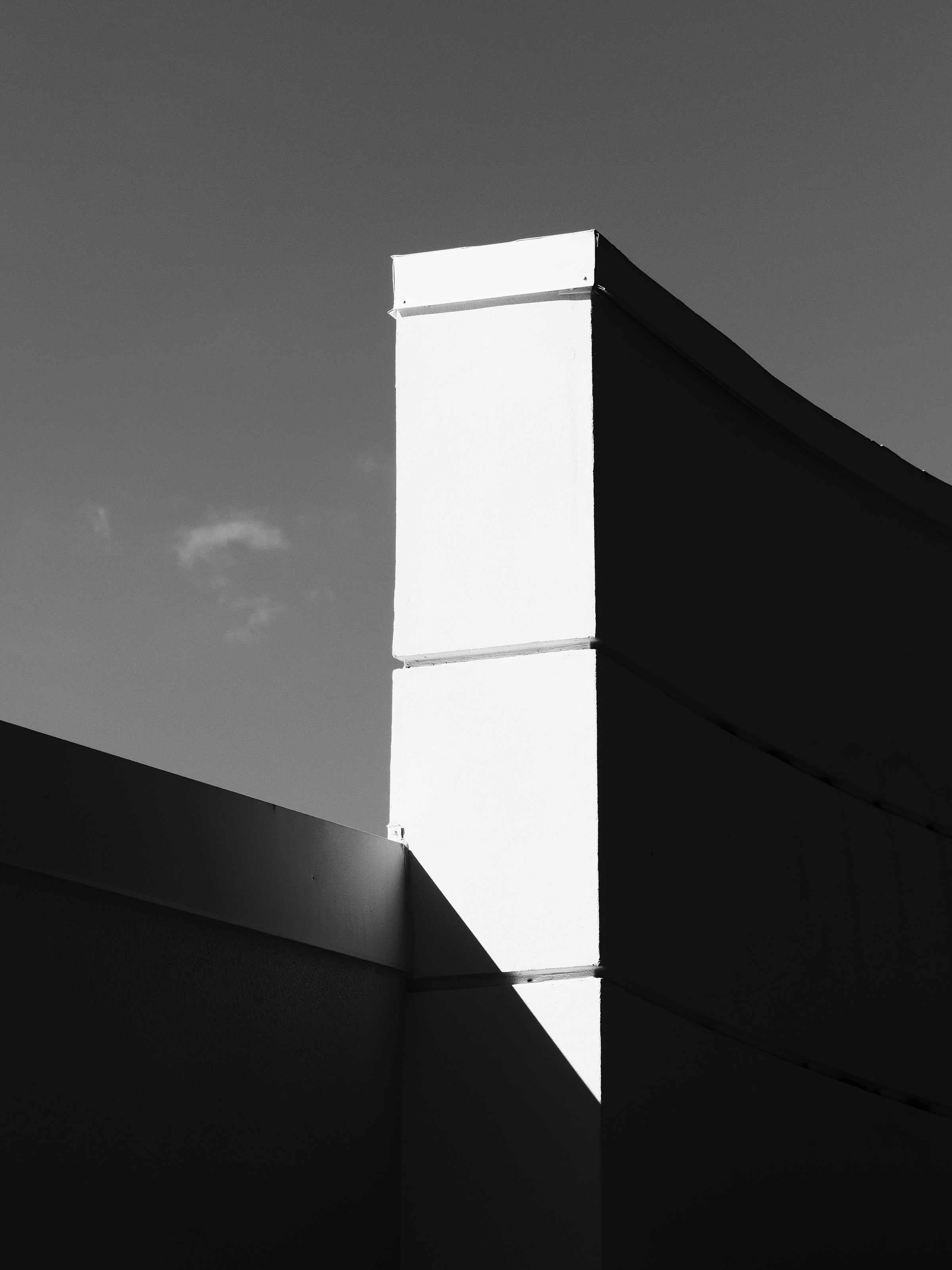 A modern building exterior with strong geometric shadows.
